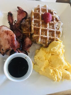 Breakfast with waffles, bacon and eggs