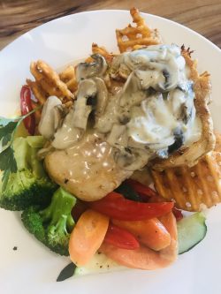 Chicken Schnitzel with waffle potatoes and mushrooms creamy sauce.